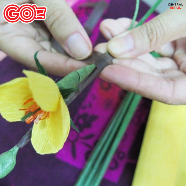 Quấn sáp nâu để kết nối hoa, nụ và lá vào kẽm nhựa, tạo thành cành hoa mai
