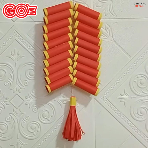 Thành quả cuối cùng: một dây pháo Tết bằng giấy màu đỏ và vàng được trang trí lộng lẫy