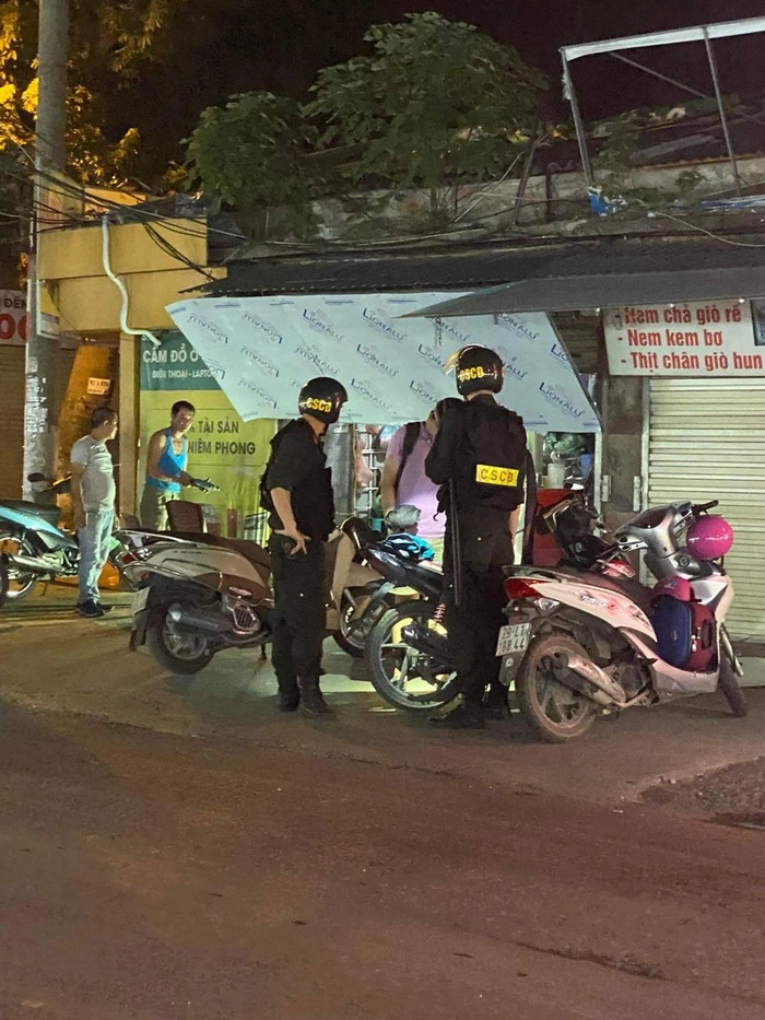 Một người đàn ông đang bị cảnh sát giao thông dừng xe để kiểm tra giấy tờ, tình huống thường gặp trên đường phố