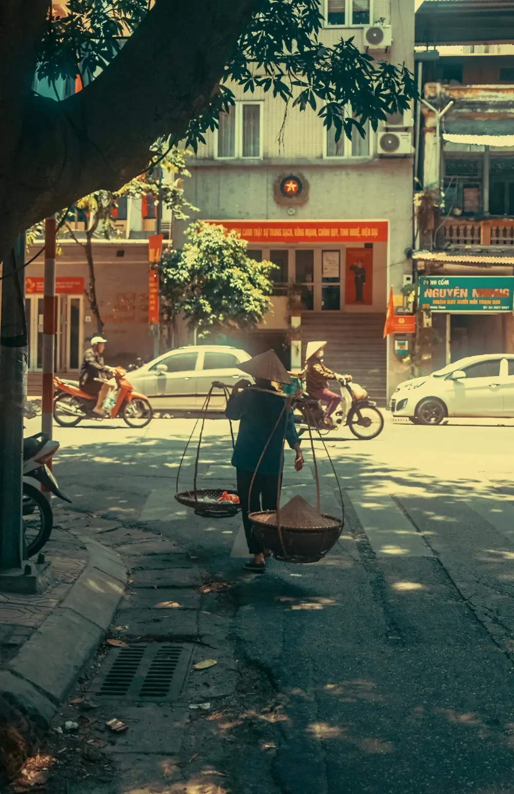 Một con đường phố đông đúc với nhiều biển hiệu chữ viết và ánh sáng đô thị