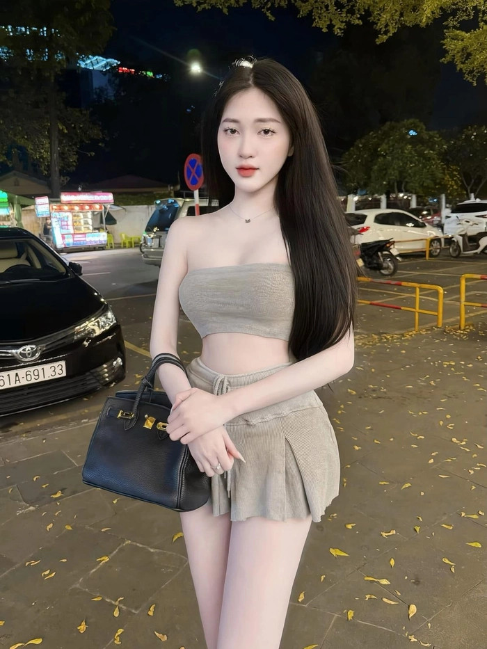 Cô gái diện váy ngắn màu kem thanh lịch kết hợp áo sơ mi cách điệu, tạo nên tổng thể hài hòa
