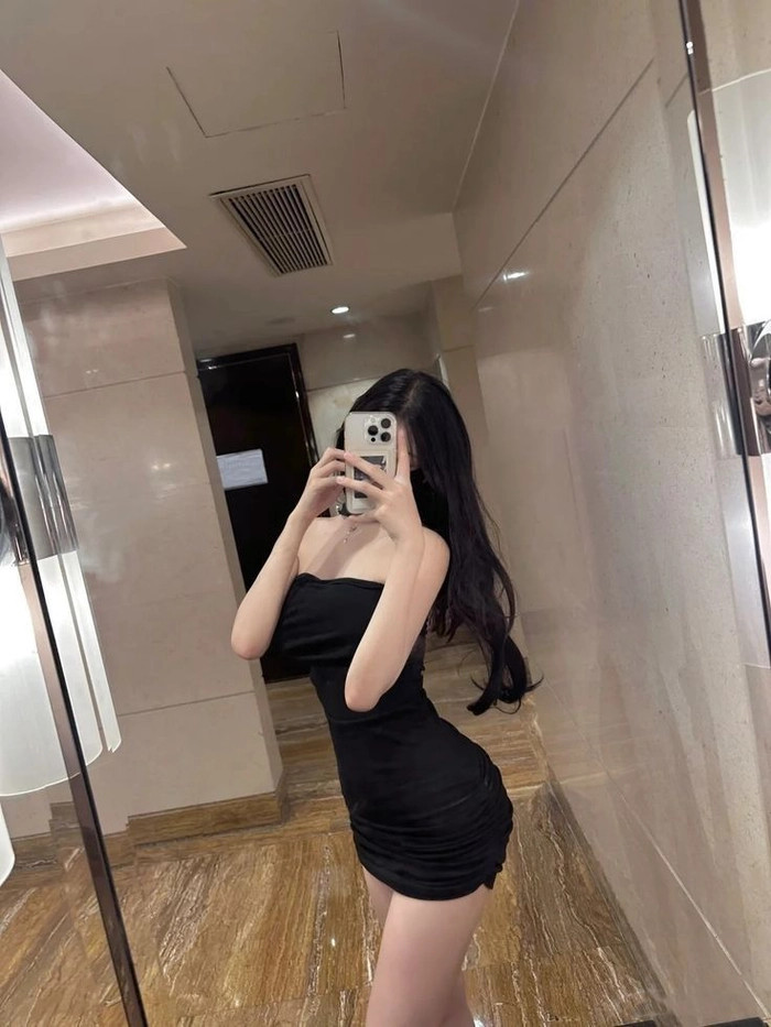 Cô gái tạo dáng đứng nghiêng để khoe khéo đôi chân thon dài khi diện váy ngắn