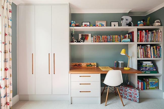 Góc học tập được decor với tủ kệ đa năng màu trắng, tích hợp bàn học, tối đa hóa không gian lưu trữ.
