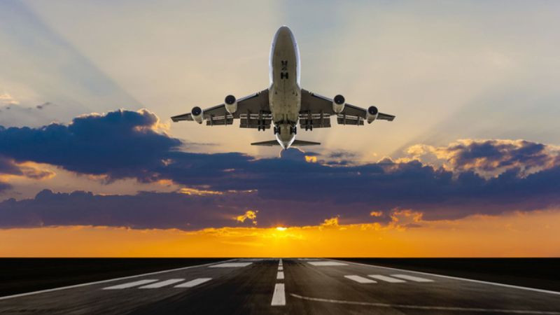 Máy bay phản lực cất cánh trong ánh bình minh vàng