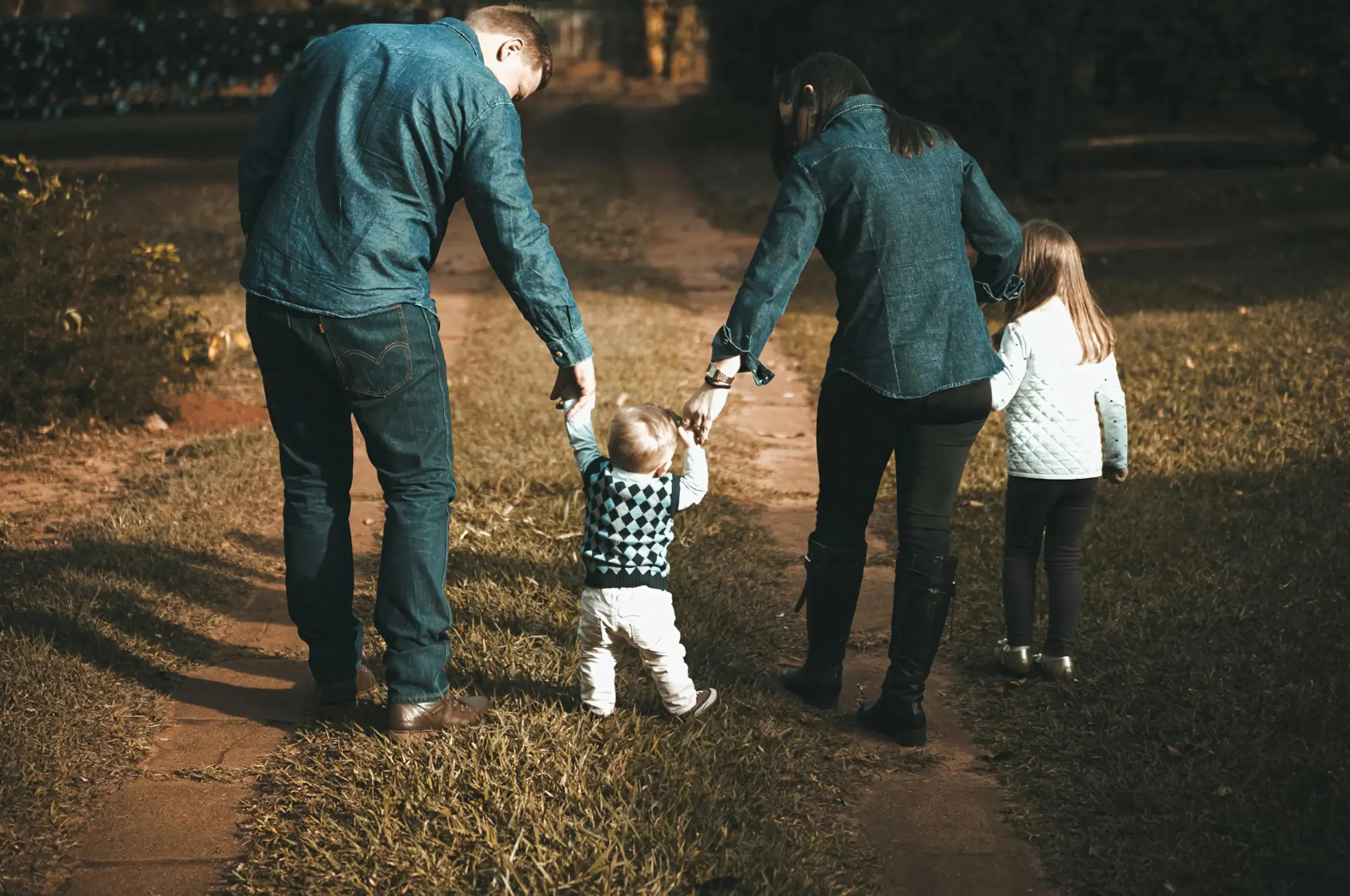 Gia đình ba người cười rạng rỡ khi cùng nhau đi dạo trên bãi biển
